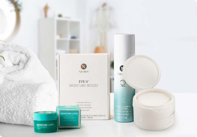 Neora’s Skincare Care Package, which includes Age IQ Double-Cleansing Face Wash, Complexion Clearing Treatment Pads, Eye-V Hydrogel Moisture Boost Patches and Moisture-Lock Lip Mask sitting on a bathroom counter. 